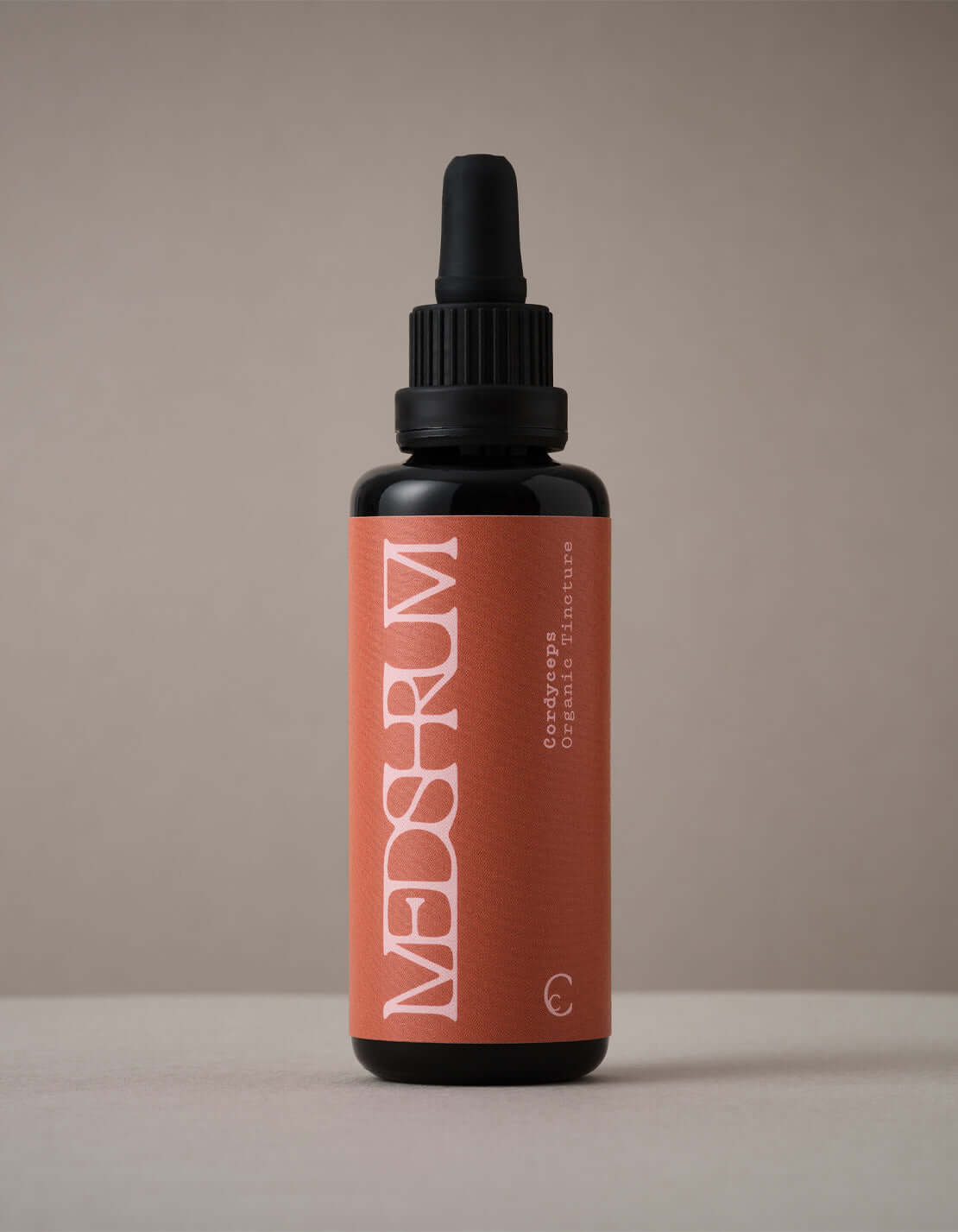 Organic Cordyceps tincture by Medshrum, shown in a glass bottle with a black dropper, on a light background.