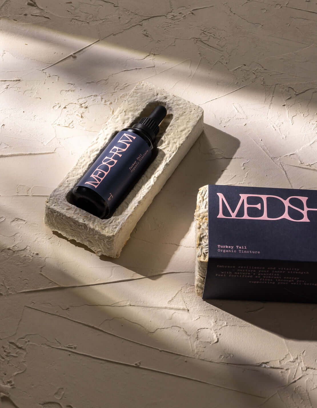 Medshrum Turkey Tail Organic Tincture bottle next to its eco-friendly packaging, sitting on a textured surface.